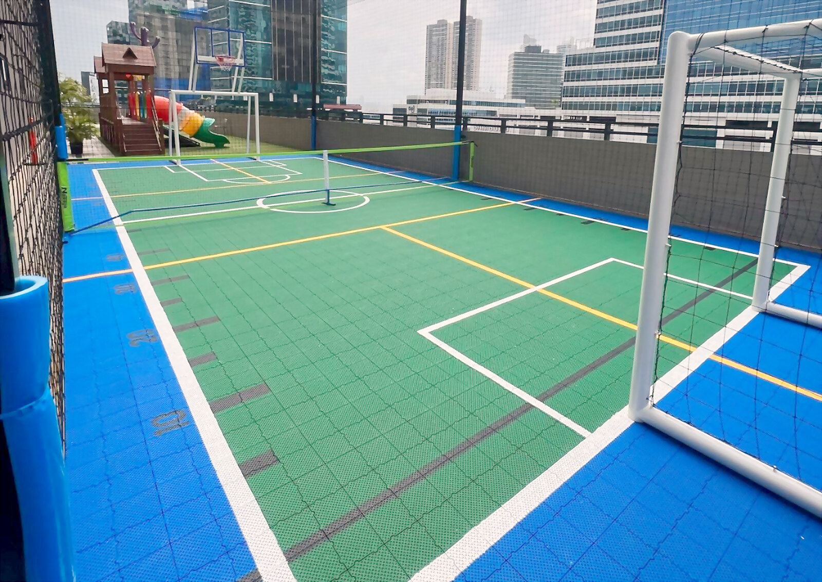 Área social residencial con suelo interlock y cancha deportiva