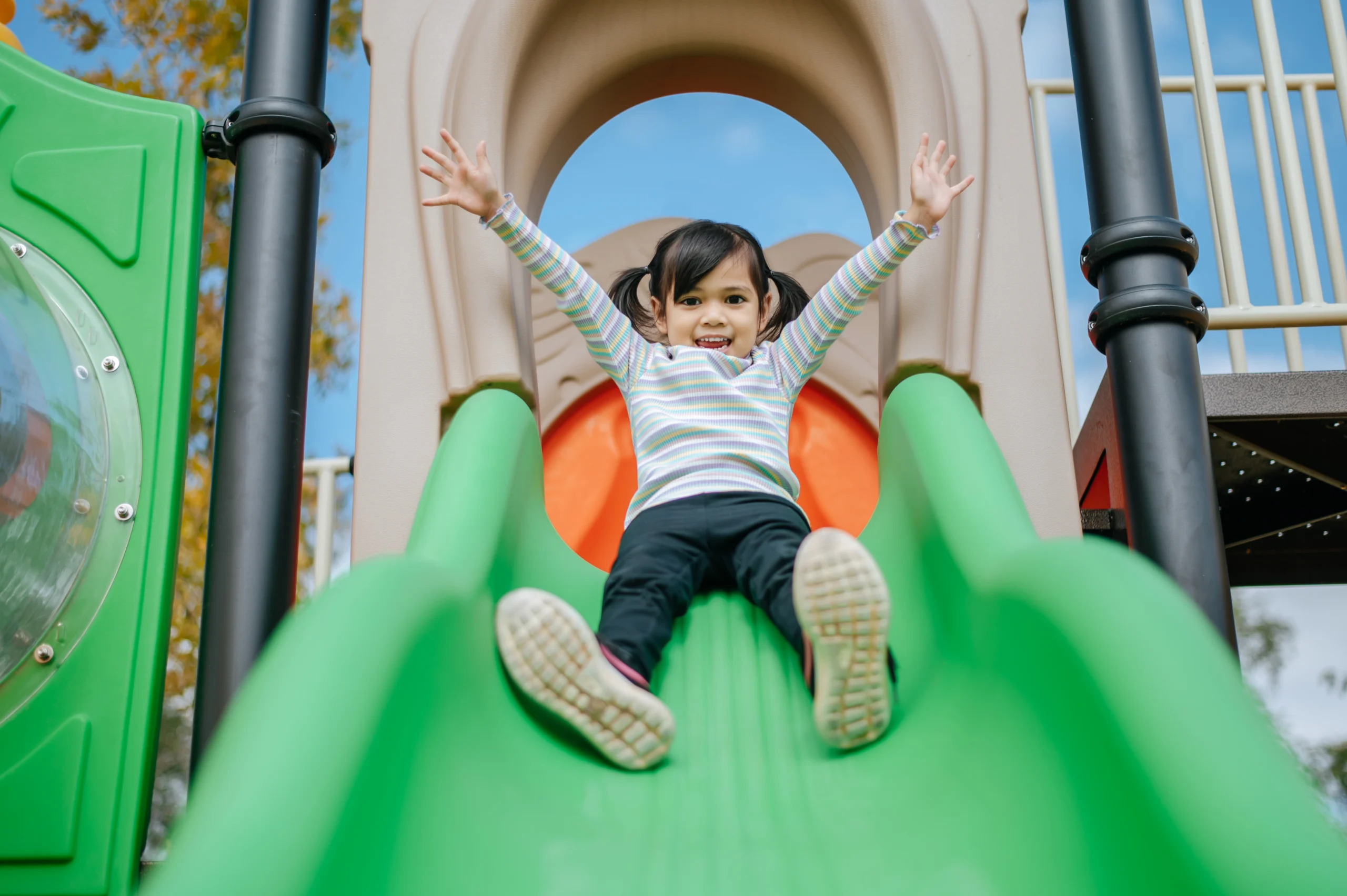 Niñas jugando en los toboganes de un parque infantil